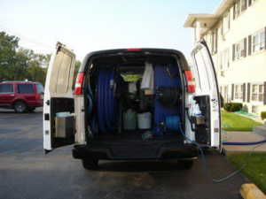 The back of a Magic Touch Carpet Cleaning van with open doors, showing hoses and equipment ready for a job in Chicago, IL.