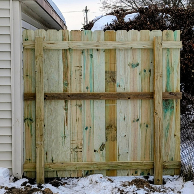The back view of a newly installed wood fence showing posts and supports by Mjölnir Design in Milwaukee, WI.