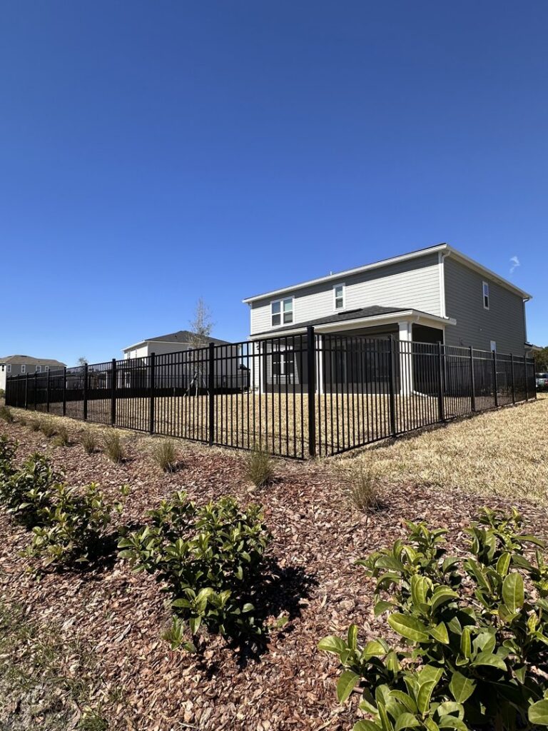 A newly installed black aluminum fence securing a residential backyard by Boost My Home in St. Augustine, FL.