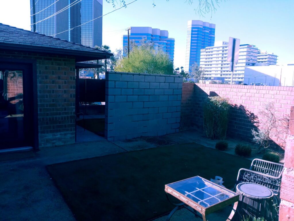 A block privacy fence enclosing a backyard with artificial turf by Arce Masonry LLC in Glendale, AZ
