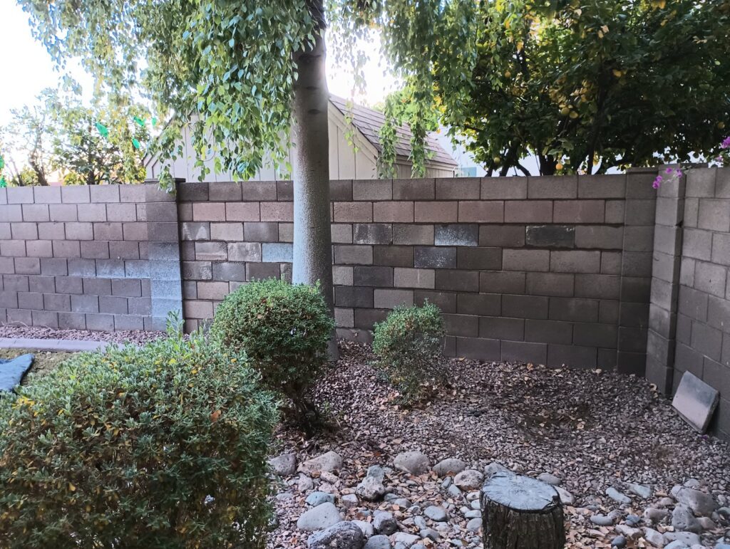 A sturdy block wall serving as a backyard fence installed by Arce Masonry LLC in Glendale, AZ
