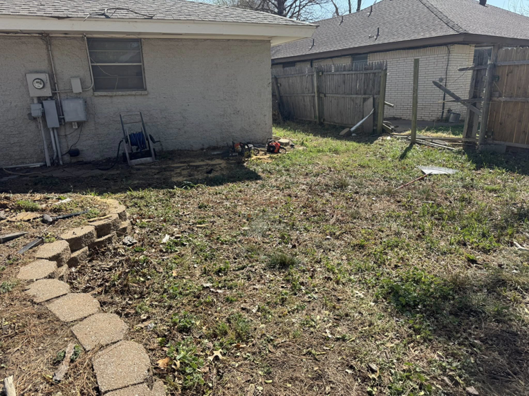 A backyard with a fallen tree and tools, ready for cleanup by Perez Lawn Care llc in Oklahoma City, OK