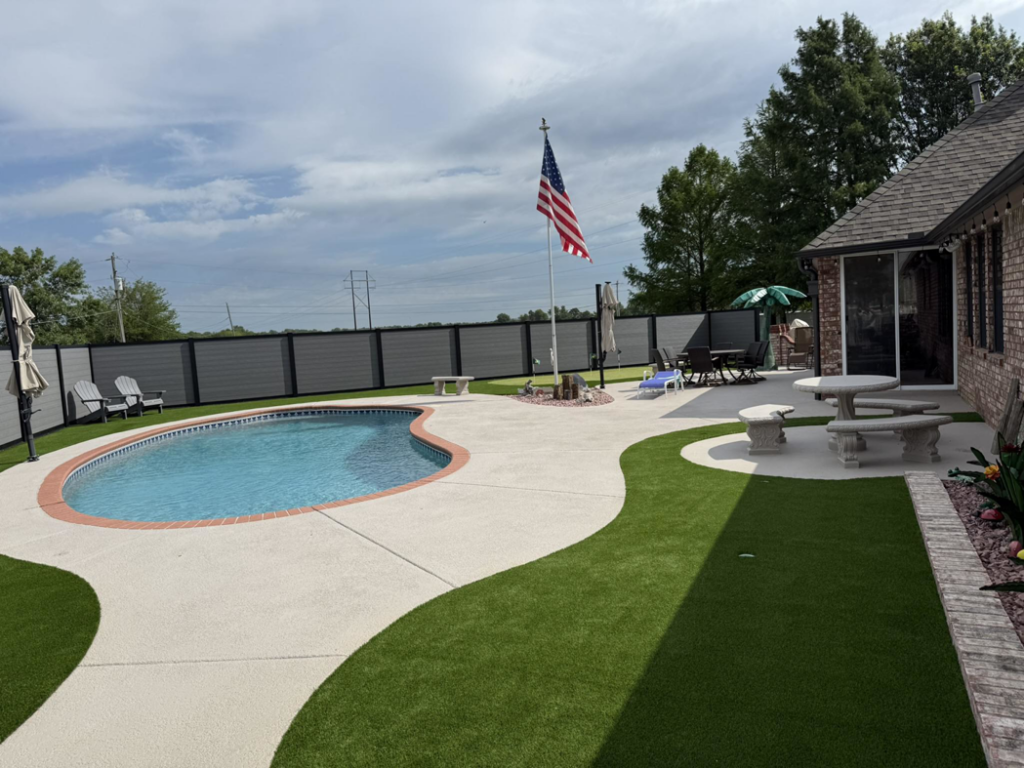 A backyard composite fence installed around a pool by Goliath Fence Systems and Pre-Stain in Oklahoma City, OK.