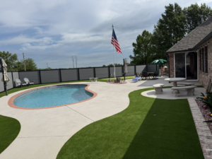 A backyard composite fence installed around a pool by Goliath Fence Systems and Pre-Stain in Oklahoma City, OK.