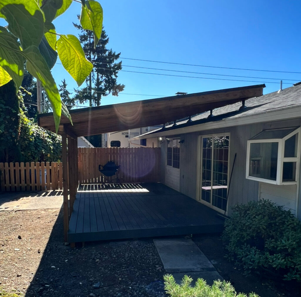 A backyard deck with a wood privacy fence in the background, installed by Clark County Fence LLC in Vancouver, WA.