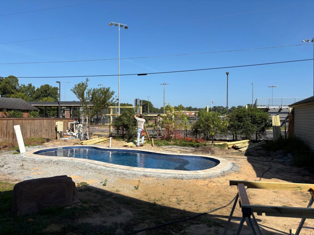Fencing installation in progress around a backyard pool area by Covenant Fence in Columbia, SC.