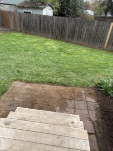 A residential backyard with lush green grass and a wooden fence, maintained by Tony's Lawn Care Services in Greenville, SC.