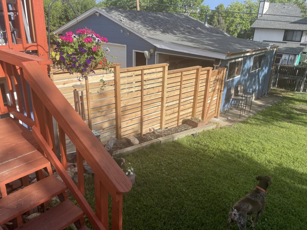 A custom horizontal slat fence enclosing a backyard space, expertly built by Accent Fence & Design in Lakewood, CO.