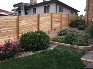A modern horizontal slat fence bordering a backyard garden, installed by Accent Fence & Design in Lakewood, CO.