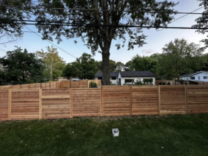 A long, newly installed horizontal slat wood fence in a residential backyard by CDM Home Solutions in Columbus, OH.