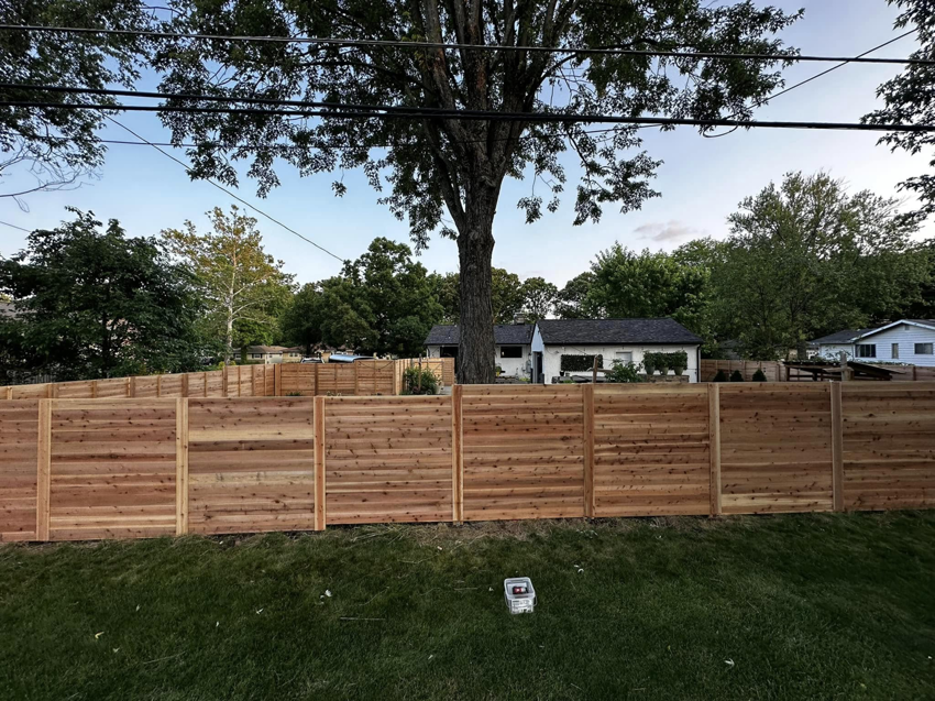 A long, newly installed horizontal slat wood fence in a residential backyard by CDM Home Solutions in Columbus, OH.