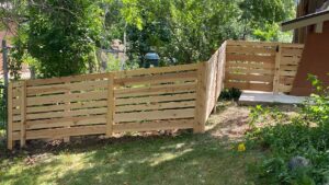 A well-crafted horizontal wood fence with a gate, enhancing a backyard space by Fence Guru LLC in Denver, CO.