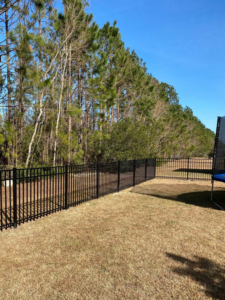 A long black metal fence installed in a residential backyard by Paragon Fence, LLC, serving Colorado Springs, CO.