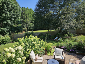 A beautiful backyard patio area with a newly installed horizontal wood fence in the background by The Fence Guy One in Greenville, SC.