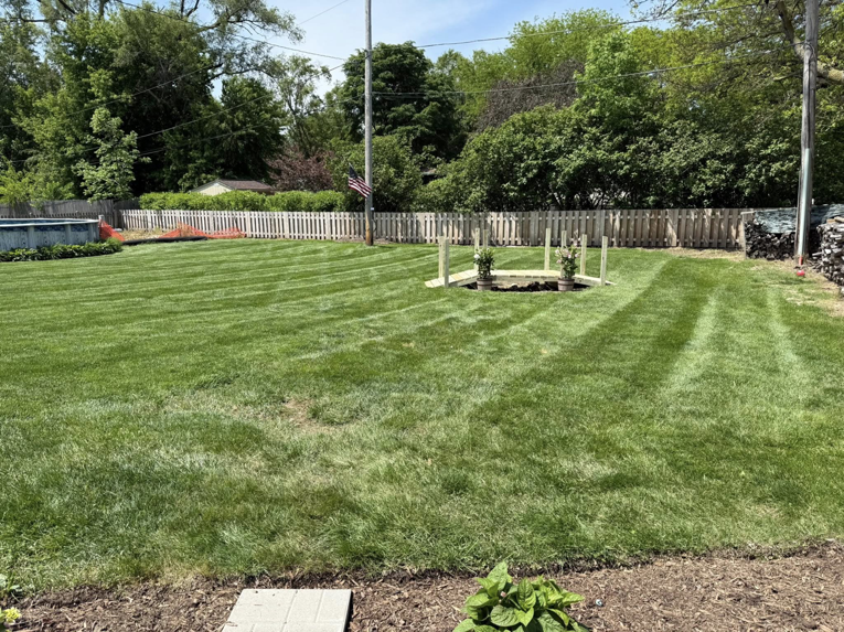 A newly installed white picket fence enclosing a residential backyard by J&L Services LLC in Toms River, NJ.