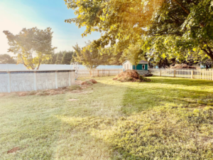 A backyard featuring an above-ground pool and a well-maintained picket fence installed by Preston's Fencing and Decks LLC in Murfreesboro, TN.