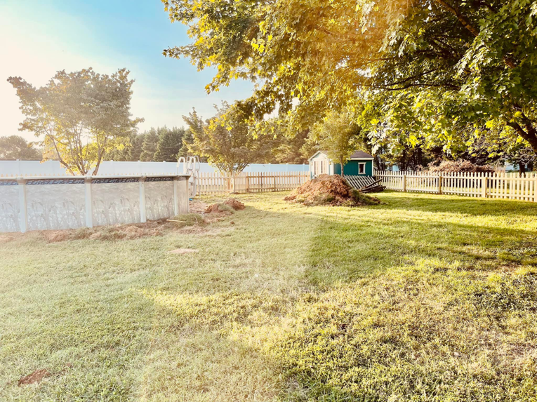 A backyard featuring an above-ground pool and a well-maintained picket fence installed by Preston's Fencing and Decks LLC in Murfreesboro, TN.