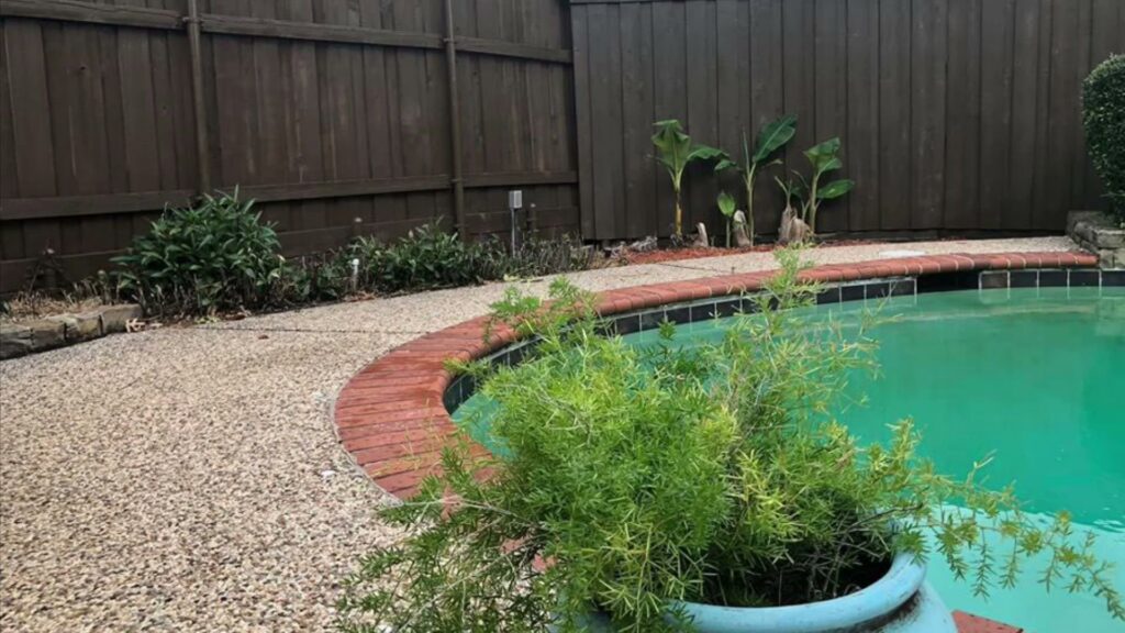 Another view of a backyard with a swimming pool and a dark stained privacy fence by Texas Tuff Stain and Seal in Fort Worth, TX.