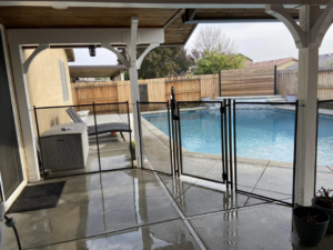 A secure backyard pool safety fence with a gate, expertly installed by A Safe Pool Enclosures in Bakersfield, CA.