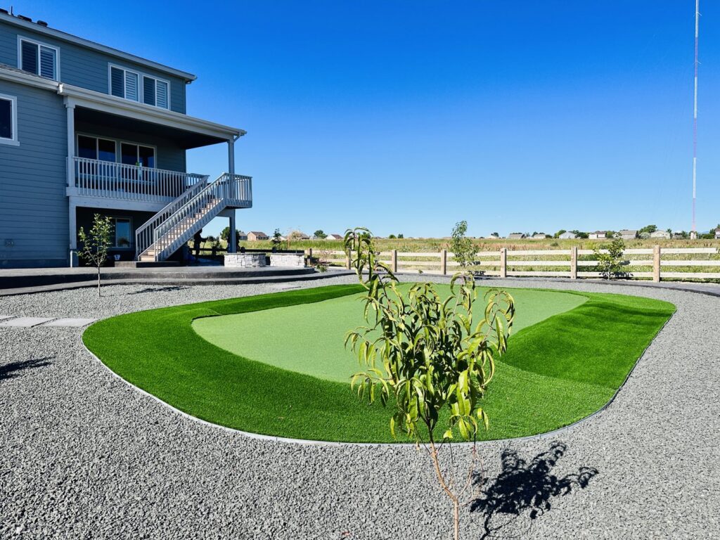 A custom backyard putting green installation with artificial turf by The Fisherman Landscaping LLC in Westminster, CO.