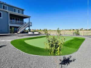A custom backyard putting green installation with artificial turf by The Fisherman Landscaping LLC in Westminster, CO.