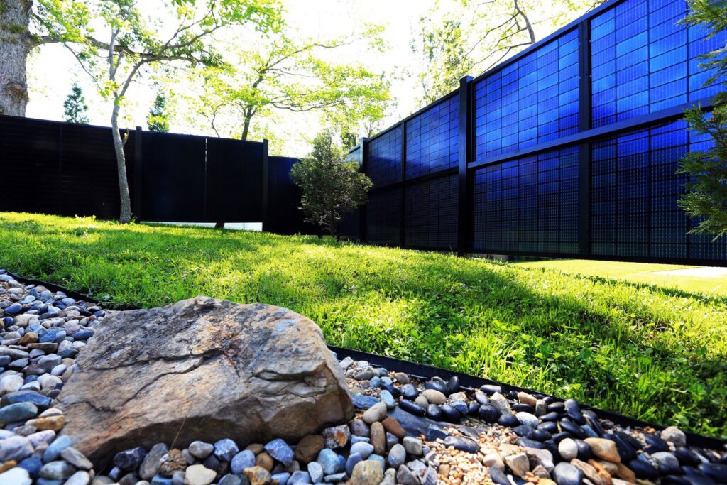 A backyard solar privacy fence installation with blue panels by Sol Fence LLC in Evansville, IN.