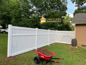 A newly installed white vinyl fence enclosing a backyard, showcasing a completed project by Limitless Boundaries LLC in Garner, NC.