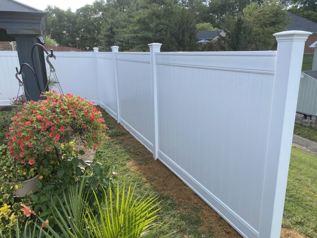A pristine white vinyl fence enhancing a well-maintained backyard by Nailed It Fencing and Exteriors in Evansville, IN.