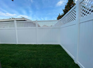 A backyard featuring a newly installed white vinyl fence with a lattice top by San Diego Fencing Contractor A's Pro Build Fencing in San Diego, CA.