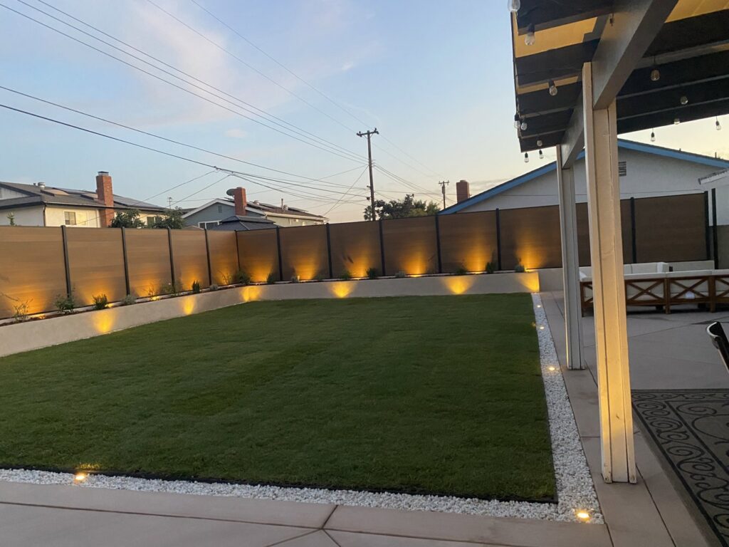 A backyard featuring a modern horizontal wood-look privacy fence installed by No Limit Fence Company in Huntington Beach, CA.