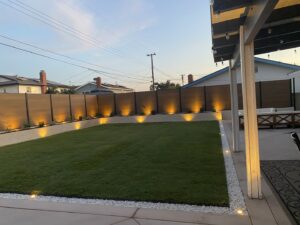 A backyard featuring a modern horizontal wood-look privacy fence installed by No Limit Fence Company in Huntington Beach, CA.