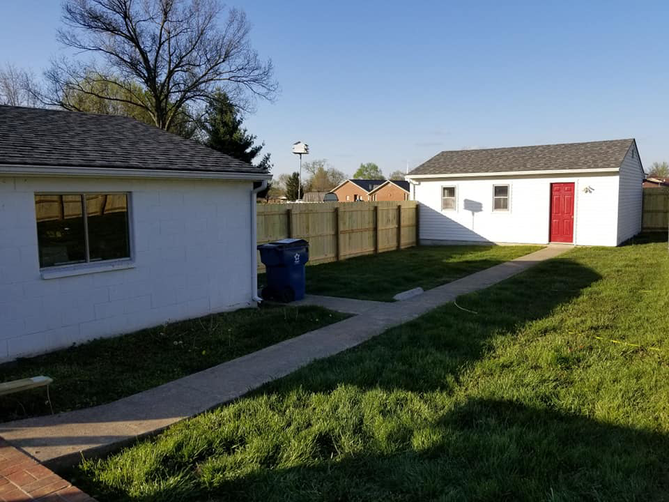A backyard featuring a newly installed wooden privacy fence by Valkyrie construction, LLC in Granville, OH.