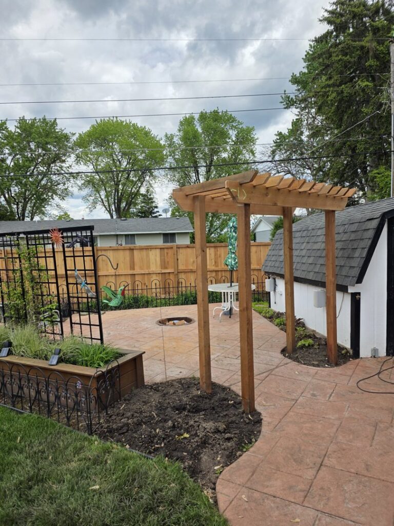 A backyard featuring a newly installed wood fence and a wooden pergola by MN Mike's Fence and Repair in Lakeville, MN.