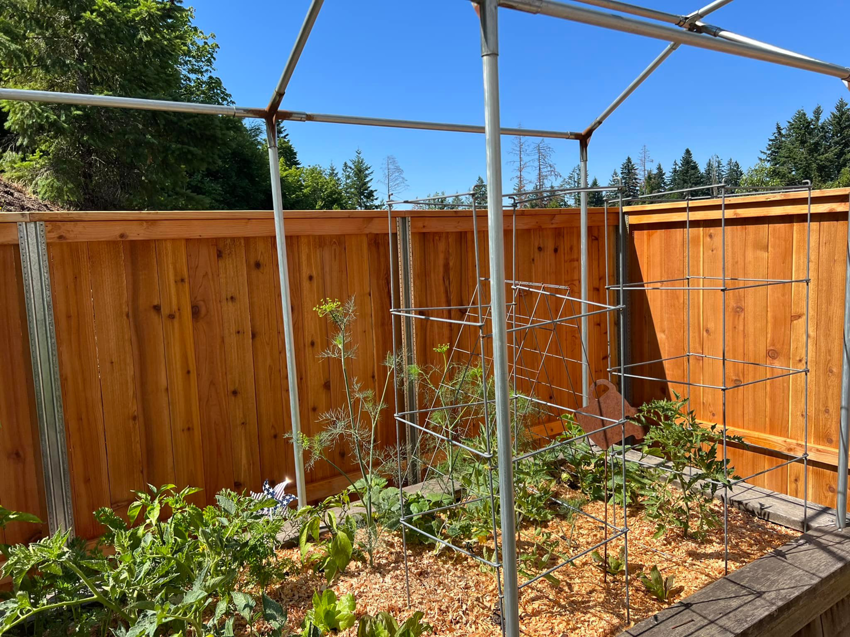 A new wood fence bordering a backyard garden, installed by RL Quality construction in Gaston, OR.