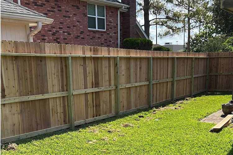 A completed wooden fence installation in a residential backyard by Alexi's Handyman Services in Indianapolis, IN.