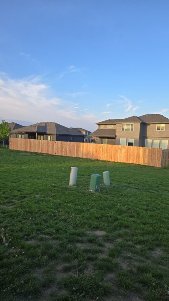 A newly installed wood fence in a residential backyard by Fencing Company Of Omaha in Omaha, NE.