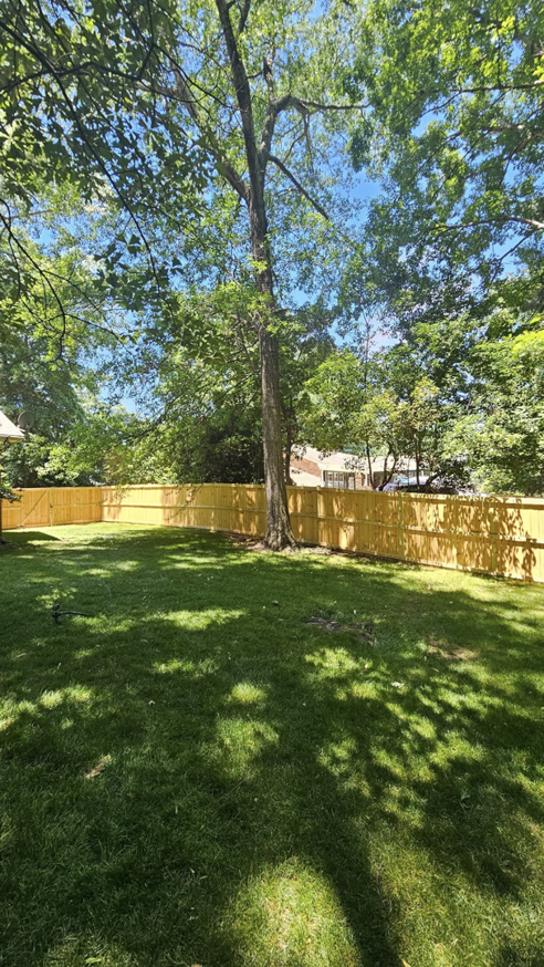 A newly installed wood fence enclosing a spacious backyard, completed by The Fence Guy One in Greenville, SC.