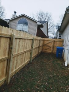 A newly installed wood fence with a gate in a residential backyard by Veteran Fence in North Royalton, OH.