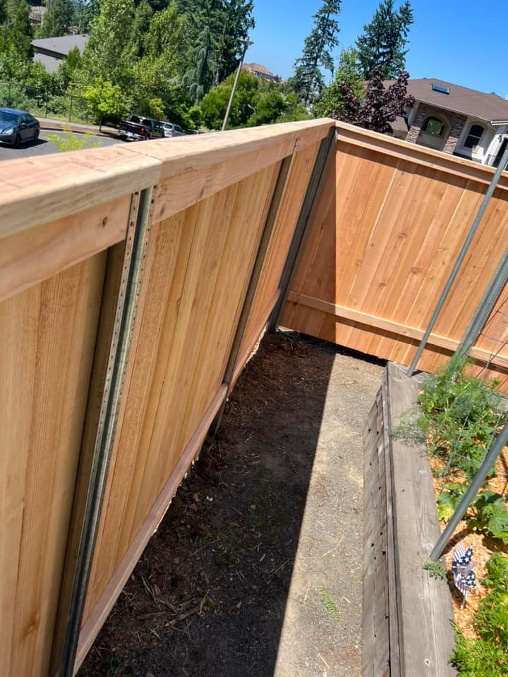 A backyard wood fence with metal posts, installed by RL Quality construction in Gaston, OR.