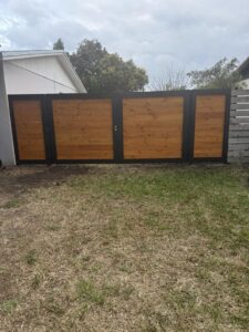 A stylish wood and metal privacy fence and gate combination installed in a backyard by A Master Work Corp. in Hialeah, FL.