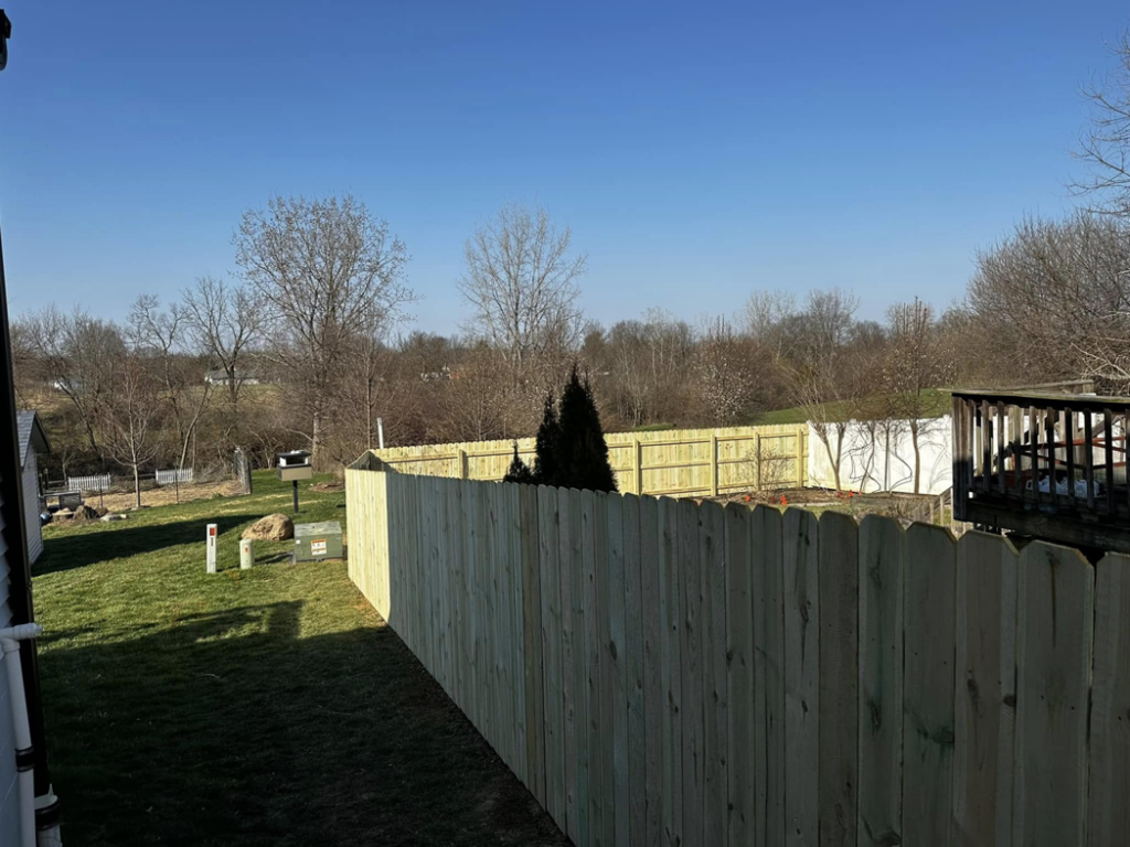 A newly installed wood picket fence enclosing a spacious backyard by CDM Home Solutions in Columbus, OH.