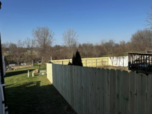A newly installed wood picket fence enclosing a spacious backyard by CDM Home Solutions in Columbus, OH.