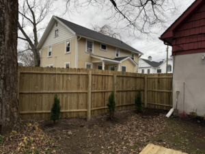 A backyard wood picket fence installation completed by Red Lake Fencing & Construction, enhancing a home in Springfield, MA.