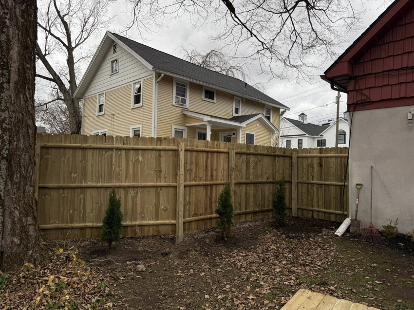 A backyard wood picket fence installation completed by Red Lake Fencing & Construction, enhancing a home in Springfield, MA.