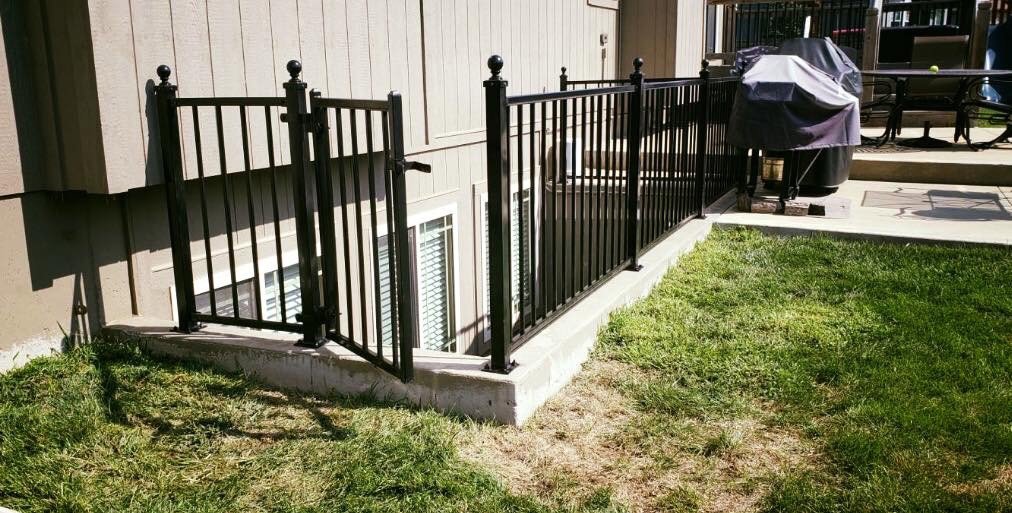 A backyard wood picket fence viewed from a deck, installed by Royal Fence & Design LLC in Olathe, KS.
