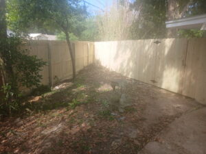 A newly installed wood privacy fence enclosing a backyard with a decorative bird bath by FenceCo LLC in Pass Christian, MS.