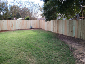 A new wooden privacy fence enclosing a backyard corner, expertly installed by Master Fence Builders in Fort Smith, AR.
