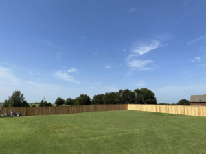 A wide view of a backyard featuring a new wood privacy fence installed by DB Construction in Fort Smith, AR.