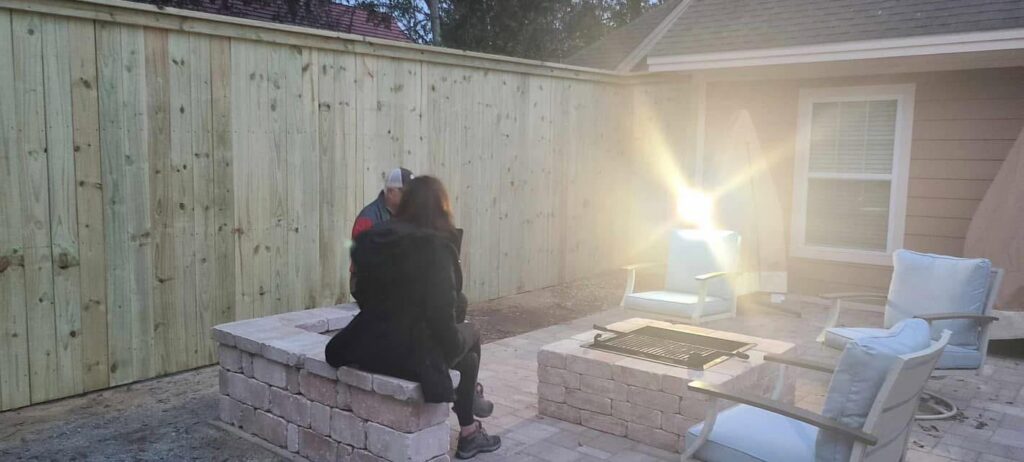 A newly installed wood privacy fence enclosing a backyard patio area by Deep South Services LLC in Biloxi, MS.