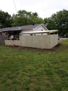 A newly installed wood privacy fence with a gate in a backyard by Lujan Fencing in Independence, MO.